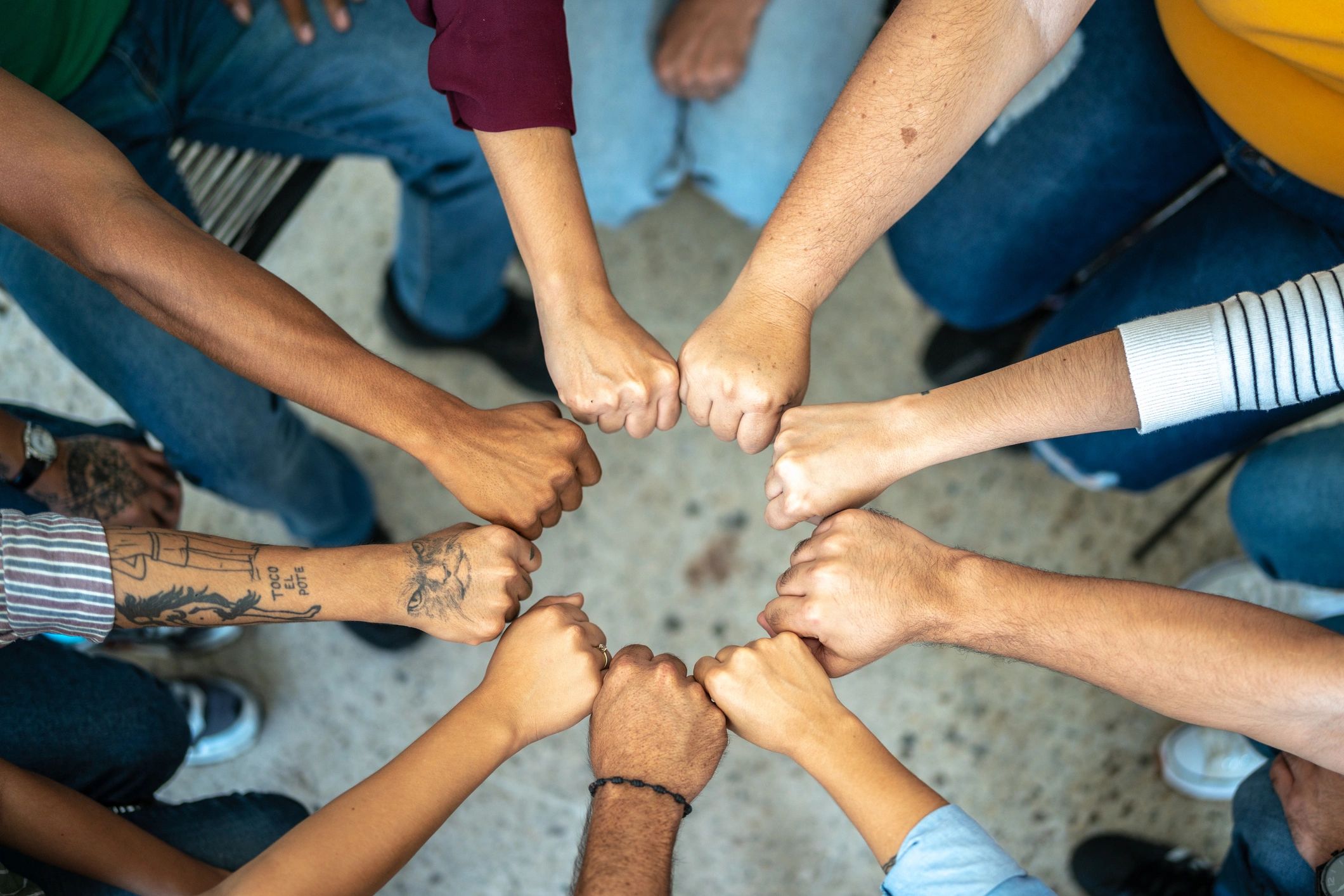 Team members joining hands in support and unity